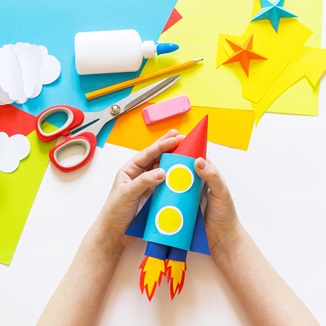 Children's craft activity building a paper rocket ship