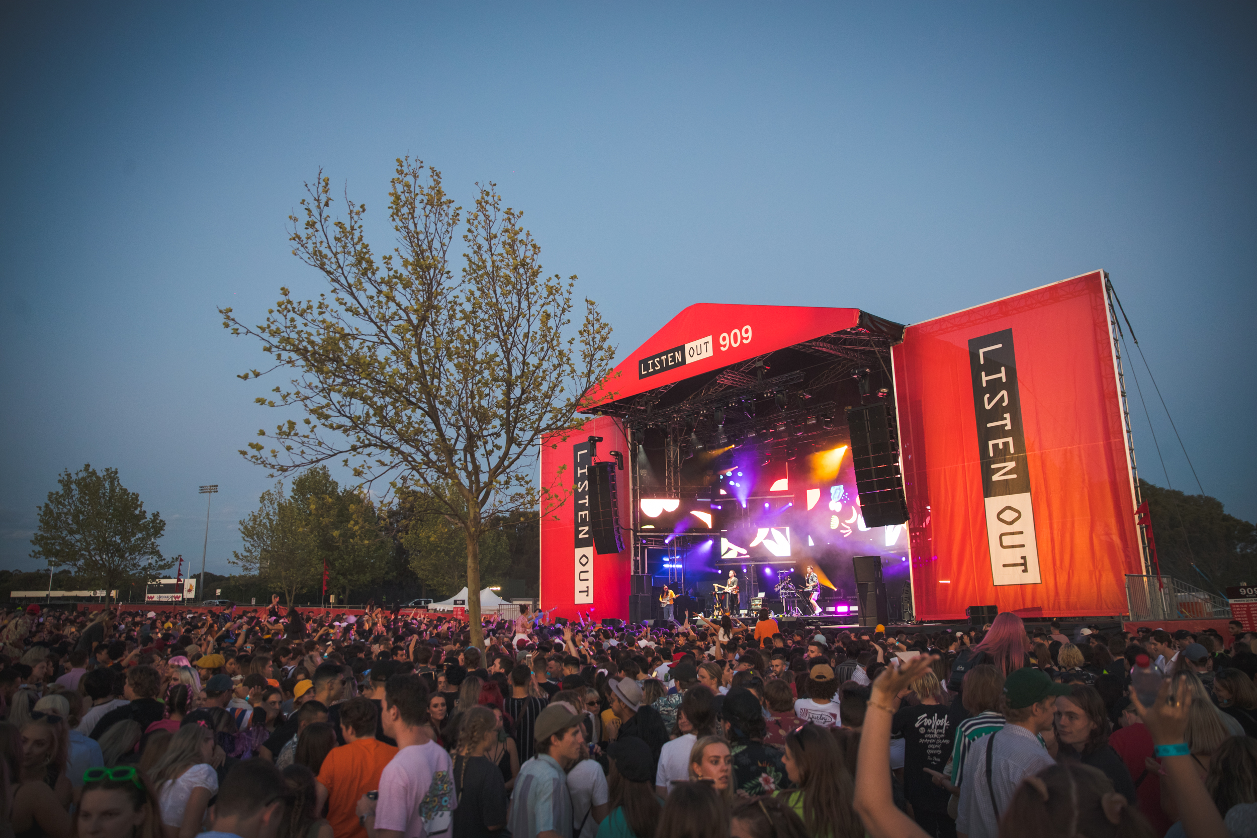 A diagonal photo of a music stage and corresponding crowd