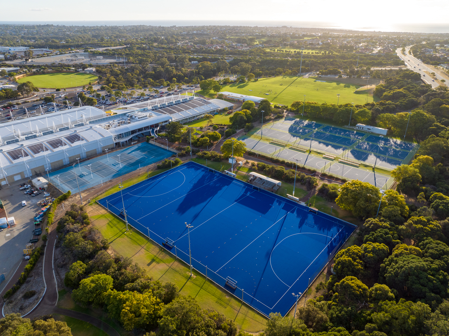 An aerial view of the Arena Joondalup complex, showing the hockey field, basketball courts, tennis courts and main building