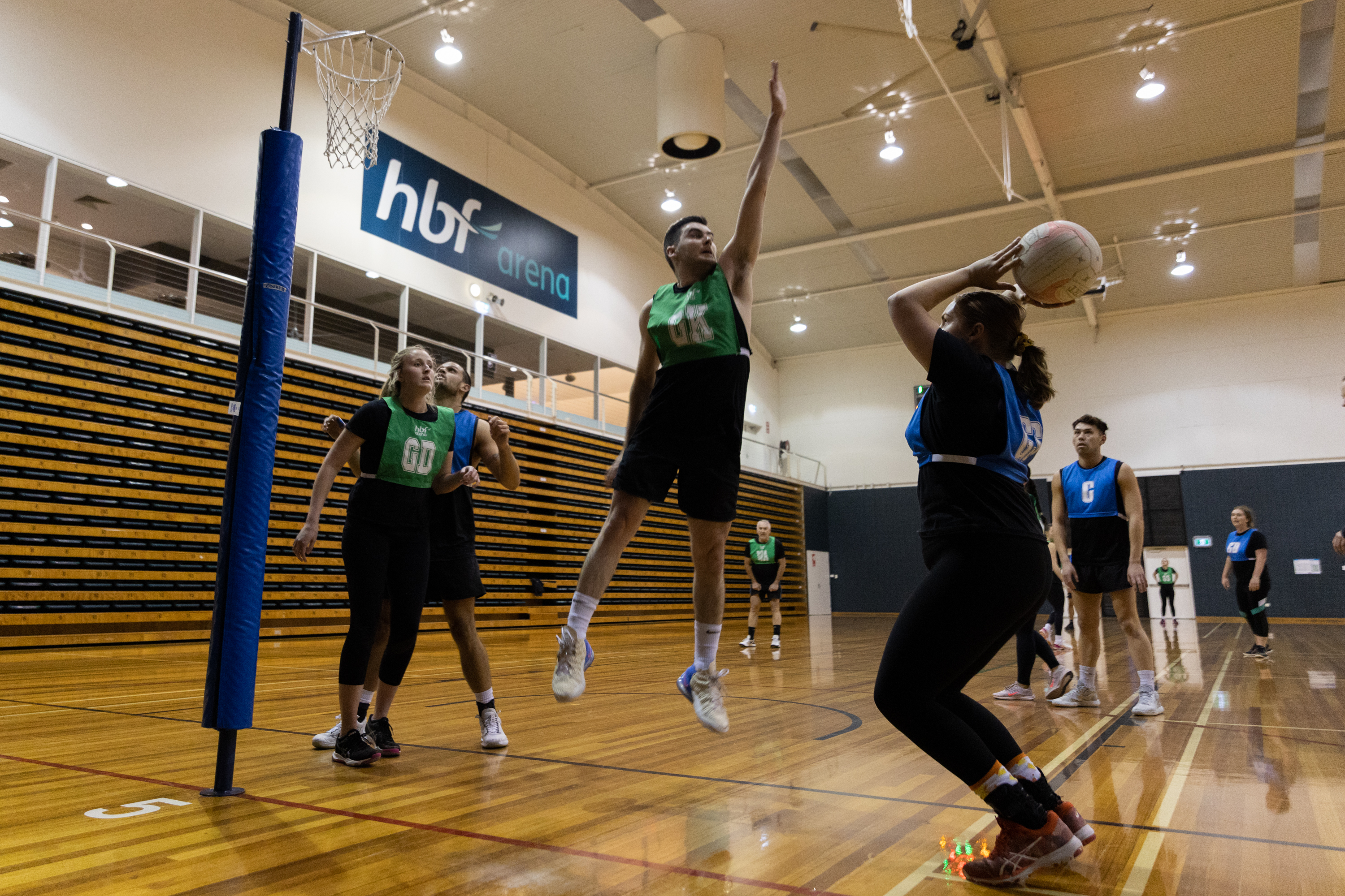 Player defending a goal shooter during a mixed netball game
