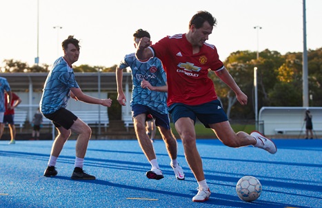Man kicking the ball during men's 6-a-side soccer game